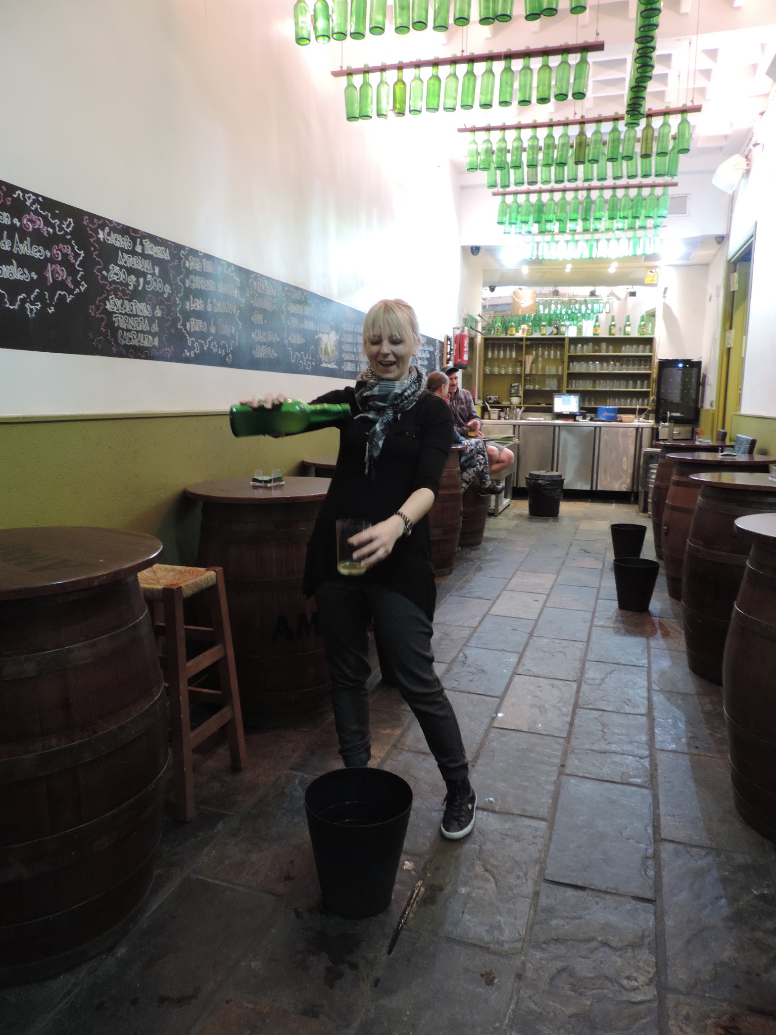 Kasia pouring cider at a traditional Asturian sidrería
